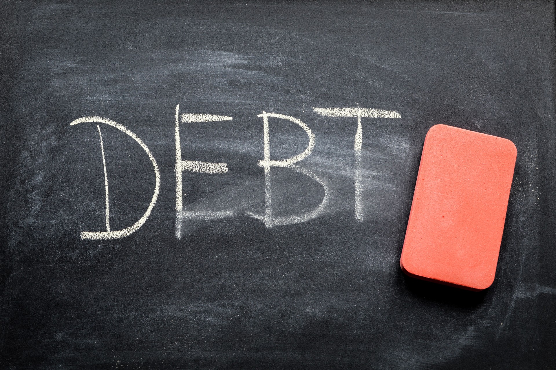 erasing debt, hand written word on blackboard being erased concept